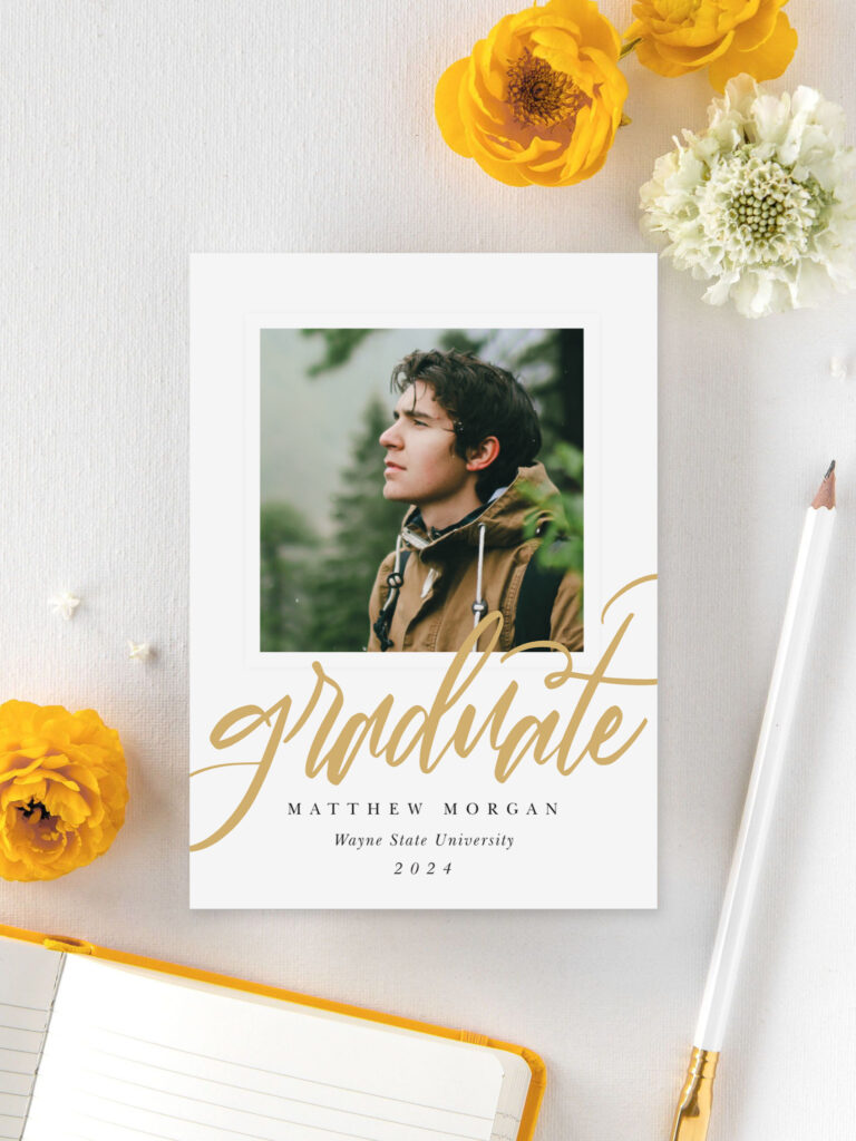 Stylish graduation announcement card with gold script text and a photo of a male graduate, designed by Basic Invite and surrounded by yellow and white flowers