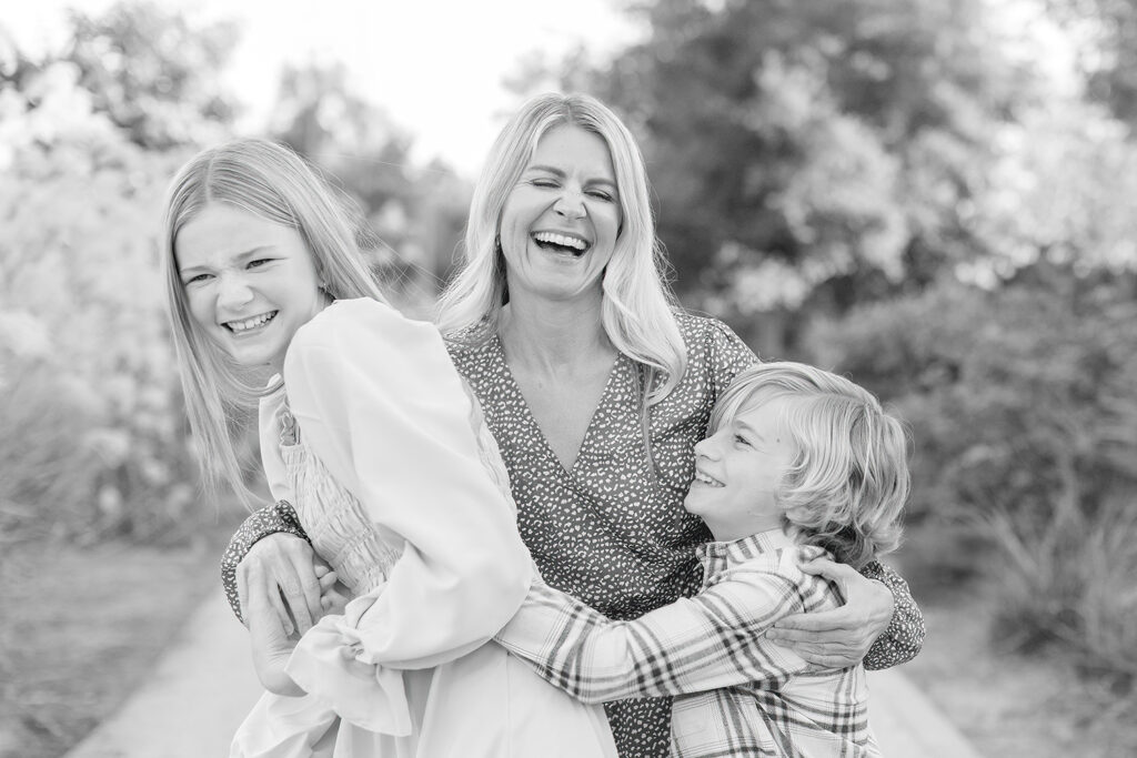 Mom laughing with her two children during a joyful family photography session at Encinitas Community Park in San Diego, California