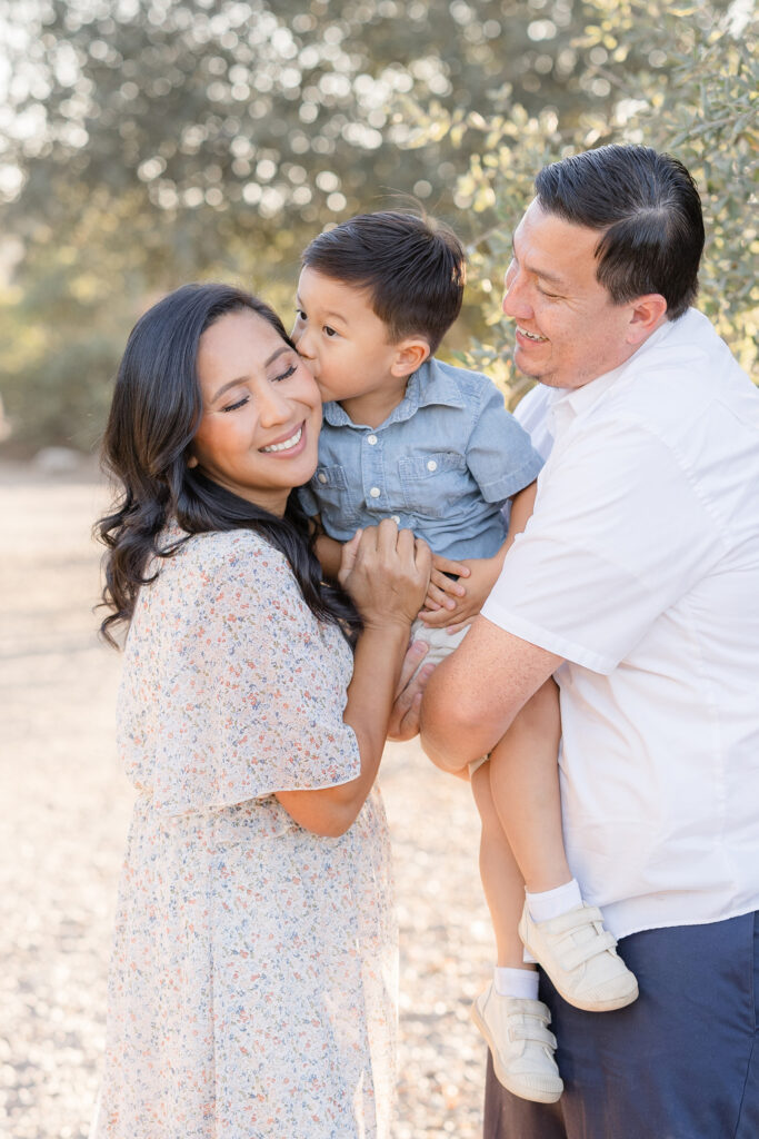 Family sharing a sweet moment during a San Diego fall mini session with their young son.
